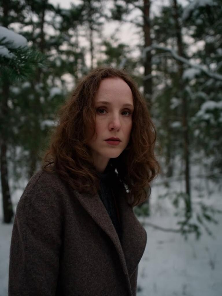 serious expression, wearing a wool overcoat