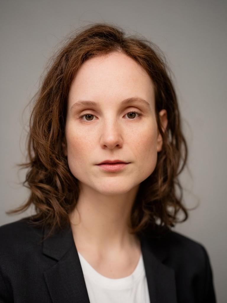 professional studio headshot, neutral expression, soft key light, plain