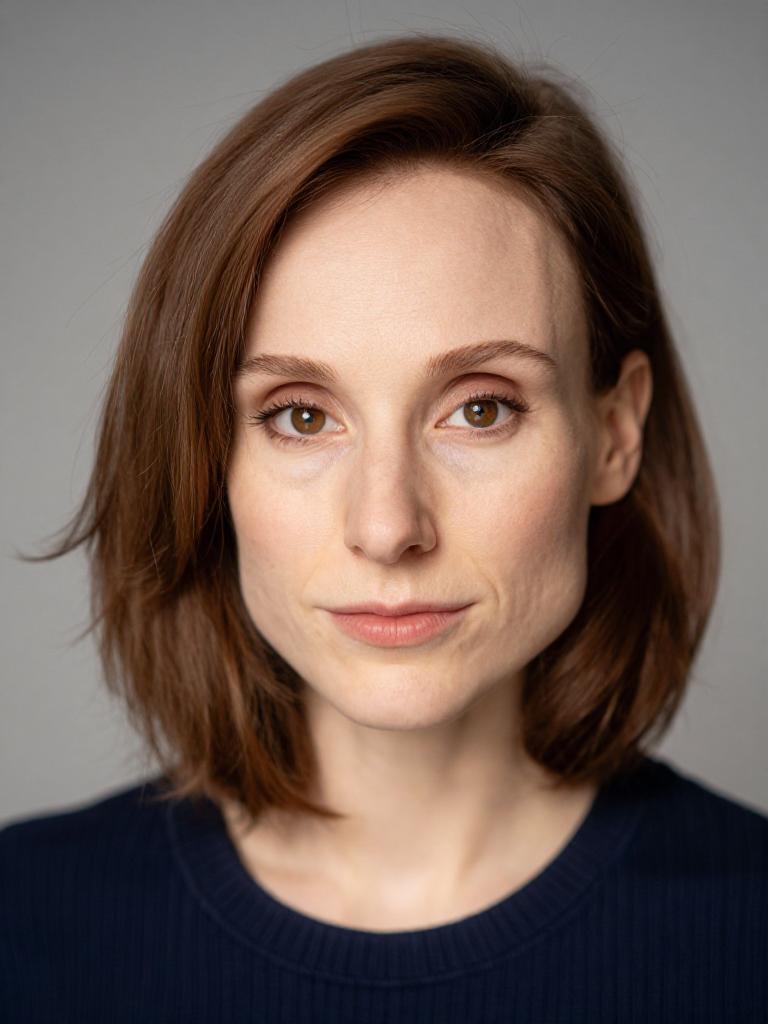 professional studio headshot, neutral expression, soft key light, plain